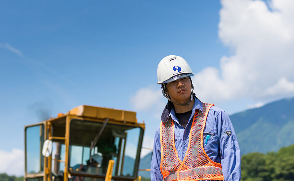 作業服を着て空を見上げる男性